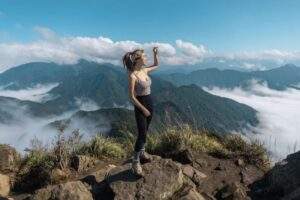 登山者在中海拔古道路線上進行 FKT 輕快登山挑戰，背景為高度植被覆蓋的山脈與 2026 年常見的高山雲海景觀