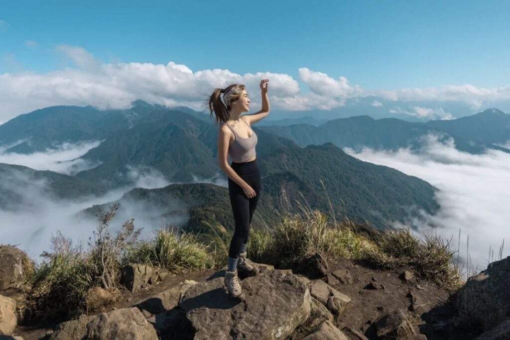 登山者在中海拔古道路線上進行 FKT 輕快登山挑戰，背景為高度植被覆蓋的山脈與 2026 年常見的高山雲海景觀