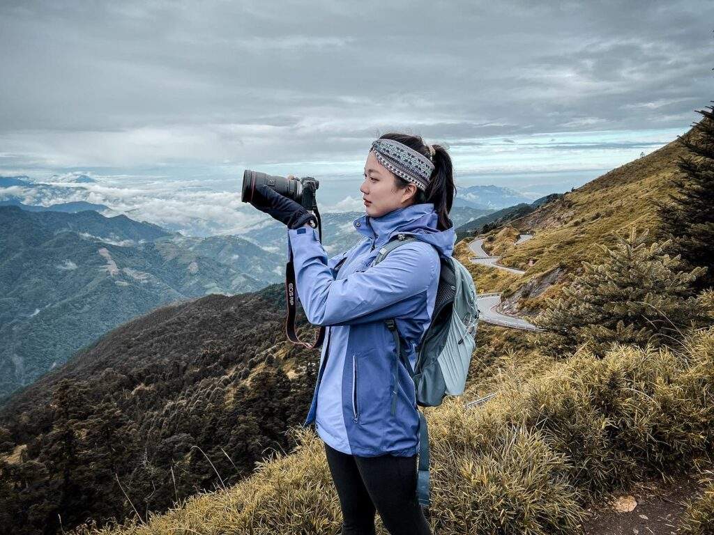 一名登山者身著專業裝備，站在高海拔山脊線上俯瞰層疊的群峰，視覺化展現經過耐力與乳酸緩衝訓練後的體能狀態，作為解析無氧閾值與高山行進效能的專業場景對應。